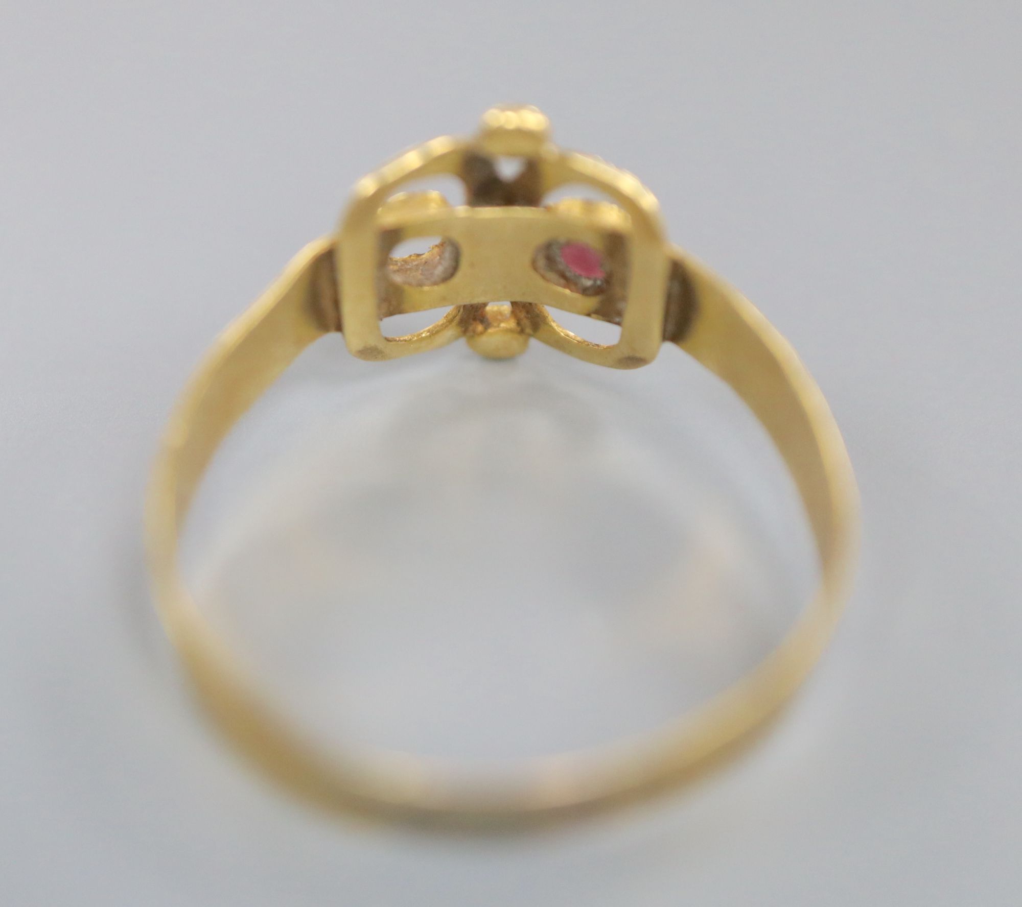 An antique reeded yellow metal and two stone set scroll ring, (stone missing and other stone chipped), size R/S, gross 1.6 grams.